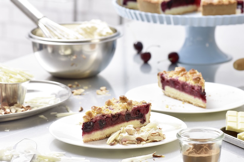 Kirschkuchen mit Butterstreuseln mit Zimt-Crème, weißer Schokolade und Salzmandeln.